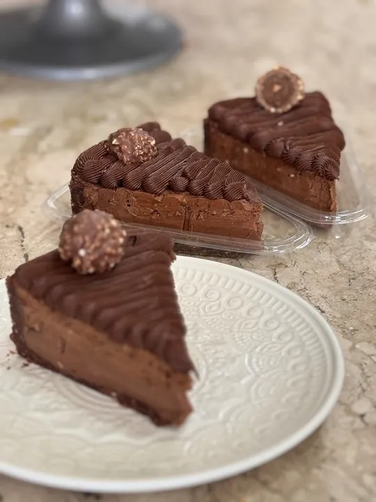 Fatia da torta tipo Ferrero Rocher com bombons de avelã no topo