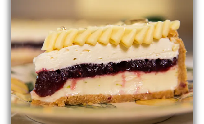 Fatia da torta de limão com geleia de frutas vermelhas e mousse de chocolate branco
