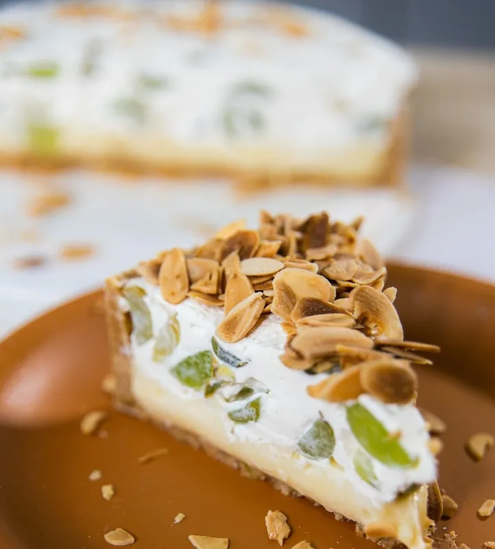 Fatia da torta Uvoffee com uvas verdes e amêndoas laminadas